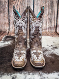 front of boots on cowhide, wood backdrop