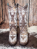 front of boots on cowhide, wood backdrop