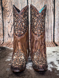 front of boots on cowhide, wood backdrop