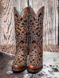 front of boots on cowhide, wood backdrop