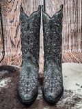 front of boots on cowhide, wood background