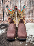 front of boots on cowhide, wood backdrop