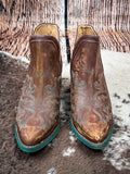 front of boots on cowhide, wood backdrop