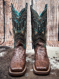 front of boots on cowhide, wood backdrop