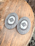 Earrings displayed on wood.
