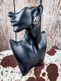 Earrings displayed on mannequin. 
