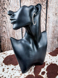 Earrings displayed on mannequin. 