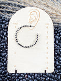 Earrings displayed on measurement board.