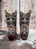 Back view of boots displayed on cowhide and wood backdrop.