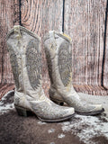 Side view of boots on cowhide and wood backdrop.