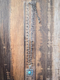 The Aster Pendant Necklace displayed on a ruler for size.