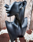 Prairie Petals Stud Fashion Earring on a mannequin, sitting on cowhide, wood backdrop.