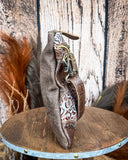 Side view of the Azure Aesthetic Leather & Hairon Bag on a wood table, wood backdrop.
