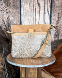 Front view of the Fennington Leather Bag in Carmel displayed on a wood table with a wood back drop.