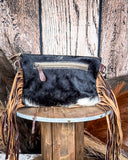 Back view of the Coral Paz Hand-Tooled Bag on a wood table with a wood back drop.