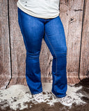 Front view of a girl modeling the Saloon Stretch Five Button Flare Jeans while on cowhide.