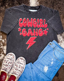 The Cowgirl Gang Vintage Graphic Tee displayed on cowhide along with shoes and jeans.