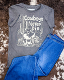 The Cowboys Never Die Distressed Graphic Tee displayed on cowhide along with jeans.
