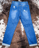 Back view of the Downtown Distressed High-Rise Mom Jeans displayed on cowhide. 
