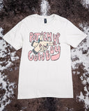 The Put 'Em Up Graphic Tee displayed on cowhide.
