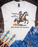 The We Ride at Dawn Graphic Tee displayed on cowhide along with shoes and jeans.