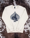 The Checkered Bronc Spade Crewneck Sweatshirt displayed on cowhide.