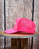 Side view of the Embroidered Rope Howdy Trucker Cap displayed on a wood table, wood backdrop.