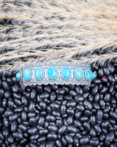 The Rayna Genuine Turquoise Bracelet displayed on beans and wheat.