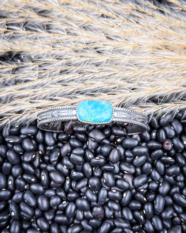 The Abha Genuine Turquoise Bracelet displayed on beans and wheat.