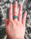 The Asia Adjustable Genuine Turquoise Ring shown on a finger with cowhide in the background.
