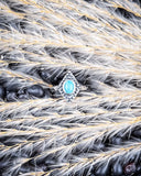 The Bahman Adjustable Genuine Turquoise Ring displayed on beans and wheat.