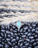 The Bahman Adjustable Genuine Turquoise Ring displayed on beans and wheat.