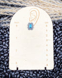 The Asia Genuine Turquoise Earrings on a ruler showing size, ruler sitting on beans and wheat.