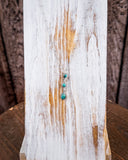 The Frida Genuine Turquoise Cascade Necklace displayed on a wood plank.