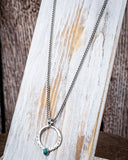 The Moongate Genuine Turquoise Necklace displayed on a wood plank.