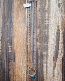 The Moongate Genuine Turquoise Necklace displayed on a ruler showing size, wood backdrop.