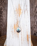 The Abeytu Genuine Turquoise Necklace displayed on a wood plank.
