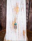 The Abey Genuine Turquoise Necklace displayed on a wood plank.