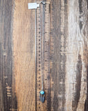 The Abey Genuine Turquoise Necklace shown on a ruler showing size, wood backdrop.
