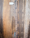 The Arrowhead Genuine Turquoise Necklace displayed on a ruler showing size, wood backdrop.