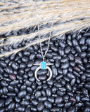 The Naja Genuine Turquoise Necklace displayed on beans and wheat.