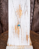 The Naja Genuine Turquoise Necklace shown on a wood ruler.