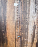 The Naja Genuine Turquoise Necklace displayed on a ruler showing size, wood backdrop.