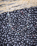 The Alana Turquoise Shaker Necklace displayed on beans and wheat.