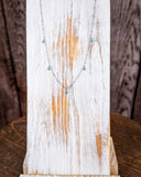 The Alana Turquoise Shaker Necklace shown on a wood plank.