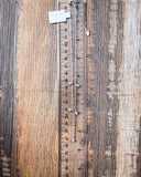 The Alana Turquoise Shaker Necklace displayed on a ruler showing size, wood backdrop.