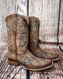 Side view of the Western Wildflower Circle G Boots in front of a wood backdrop.