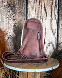 Back view of the Cimarron Tooled Sling Bag on a wood backdrop.