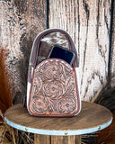 Front view of the Cimarron Tooled Sling Bag to show off front pocket on a wood backdrop.