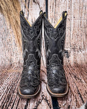 Front view of the Midnight Slither Corral Boots in a wood backdrop.
